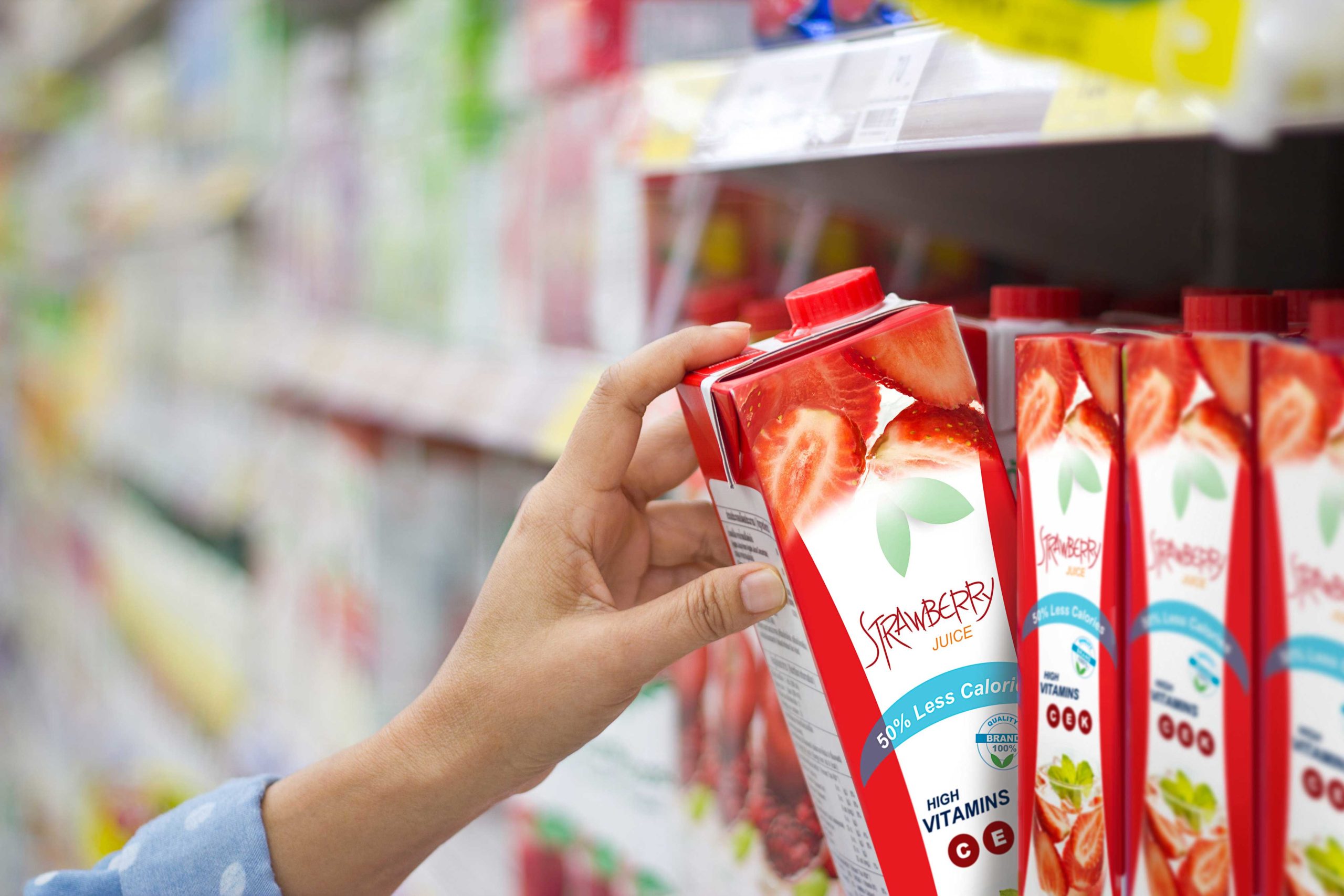Hand reaching for strawberry juice on grocery store shelf